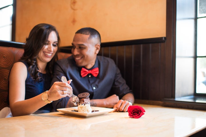 The couple cozied up next to each other in the booth. 