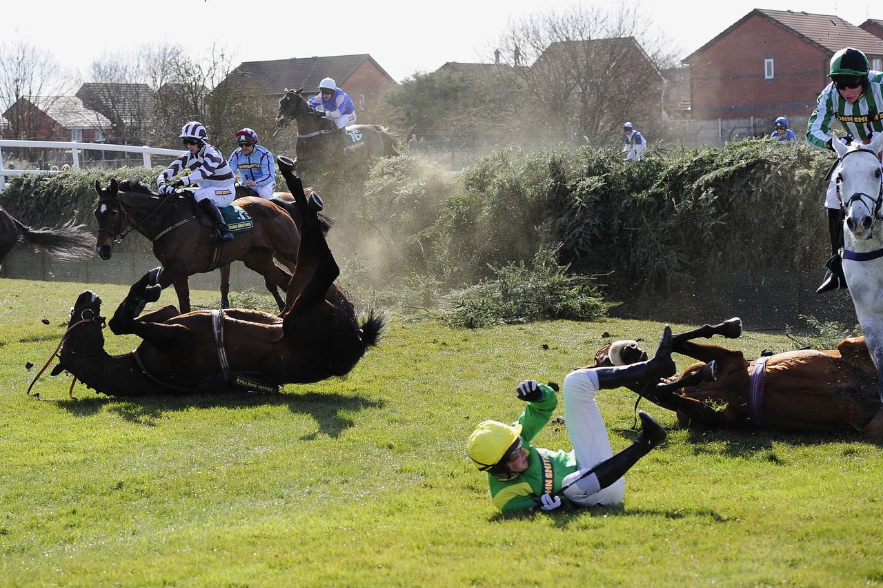 Silverburn and Mr J. Tudor fall at Bechers Brook in the John Smiths Fox Hunters Chase during Grand Opening Day of the 2013 Grand National