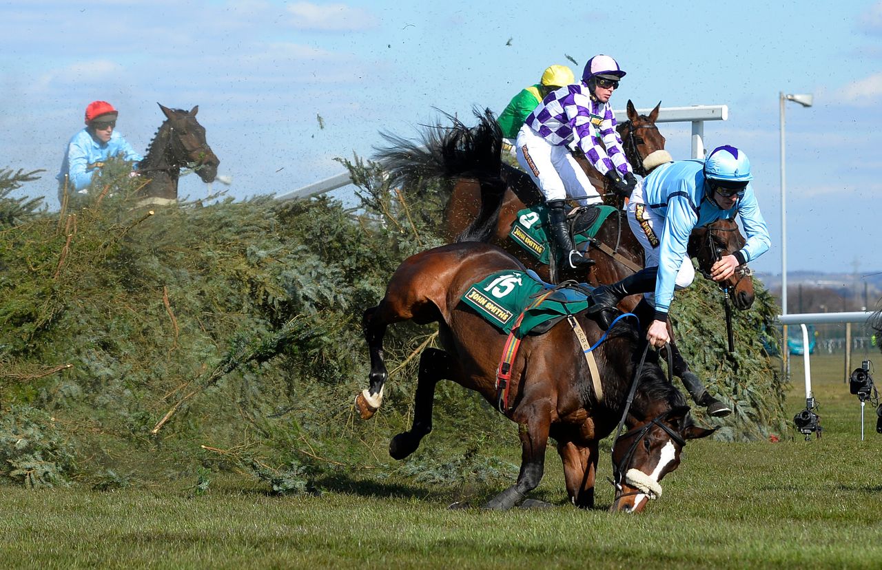 Ben Crawford falls off his horse Paddy Mourne at the Chair during the Fox Hunters' Steeple Chase at Aintree, April 4, 2013