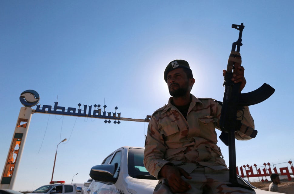 A member of Libyan forces loyal to Haftar sits on a car in front of an oil terminal. West of Benghazi, Libya. Sept. 14, 2016.