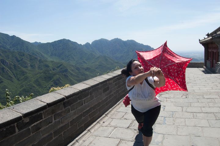 <p>Hiking the Great Wall of China with a flimsy umbrella</p>