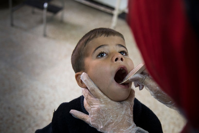 International Medical Corps' Dr. Saja Alsanjry checks a boy suffering from a fever at the primary health clinic in Gogjali, a