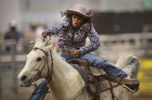 A cowgirl participates in the barrel race competition.