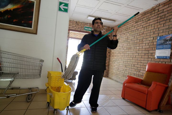 Beristain mops the floor of a migrant shelter in Juarez, Mexico.