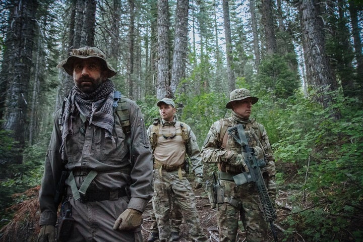 Dr. Mourad Gabriel (left) pauses to listen for signs of movement as he and the team of law-enforcement officers moves toward