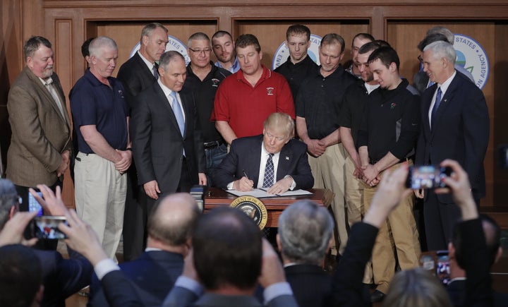 President Donald Trump signs an executive order on March 28 at the Environmental Protection Agency, aiming to unravel former President Barack Obama's plan to curb global warming.