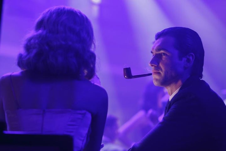 Hef with his trademark pipe and trademark beautiful girl.