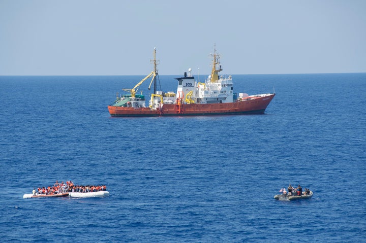 Members of the SOS Mediterranean ship MS Aquarius rescue migrants on a small craft in the Mediterranean Sea. July 29, 2016.