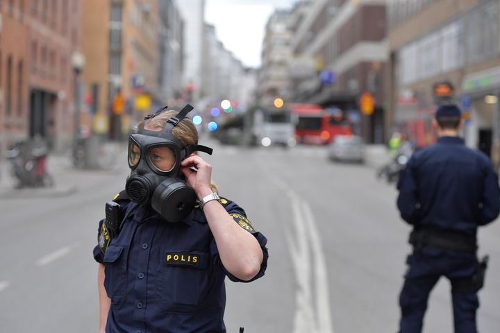 Police officers wear gas masks as they stand guard near the shopping centre