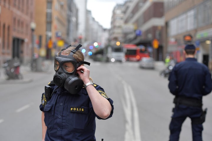 Police officers wear gas masks as they stand guard near the shopping centre