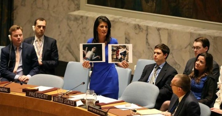 U.S. Ambassador to the United Nations Nikki Haley holds photos of victims as she speaks as the U.N. Security Council meets in an emergency session on April 5, 2017, about Syria. 