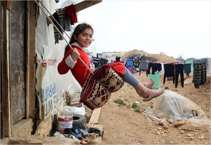 A girl plays on a swing, in the Faida informal tented settlement for Syrian refugees, in the Bekaa Valley.