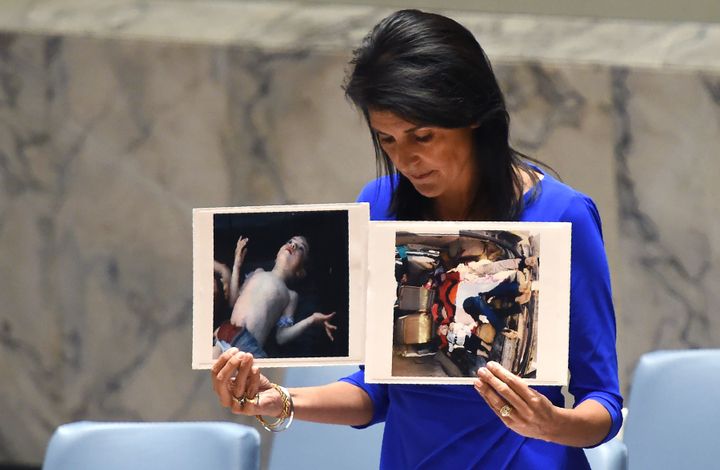 US Ambassador to the UN, Nikki Haley holds photos of victims as she speaks as the UN Security Council meets in an emergency session at the UN on April 5, 2017, about the suspected deadly chemical attack that killed civilians, including children, in Syria.