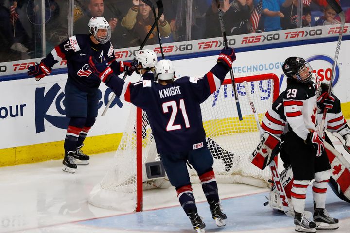 Kacey Bellamy (No. 22) of the U.S. celebrates a third-period goal with Hilary Knight.