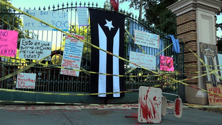 <p>Río Piedras campus main entrance blocked with barricades accompanied by artwork (April 3, 2017).</p>