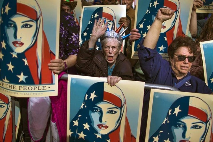  People carry posters during a rally against President Donald Trump's executive order banning travel from seven Muslim-majority nations, in New York's Times Square on Feb. 19. Andres Kudacki AP