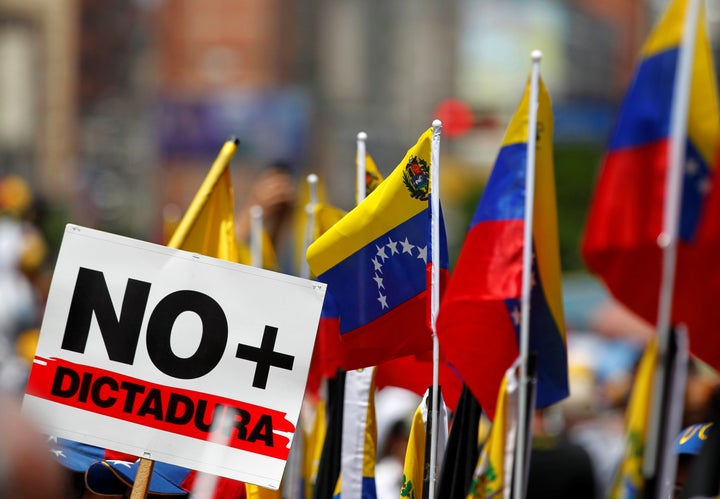 A signs that reads "No more dictatorship" and Venezuelan flags are seen during an opposition rally in Caracas, Venezuela, April 8. 