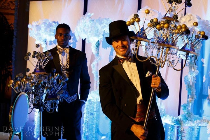 Waiters serve candelabras with cake pops.