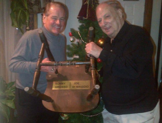 NY Rangers legend Rod Gilbert and Det. Grosso hold up the Manducati Restaurant’s chair that the Yankee Clipper sat on while having dinner with Sonny