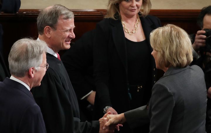 Supreme Court Chief Justice John Roberts shakes hands with Education Secretary Betsy DeVos as they arrive to President Trump's joint session of the Congress on February 28, 2017.