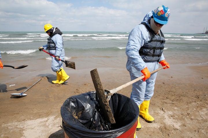 Oil spill response contractors clean up crude oil on a beach after a BP oil spill on Lake Michigan in Whiting, Indiana March