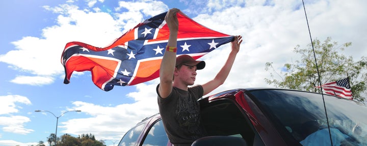 A protester with a Confederate flag drives past other demonstrators in Roseburg, Oregon, in October 2015. President Barack Obama was visiting a week after the mass shooting at Umpqua Community College.