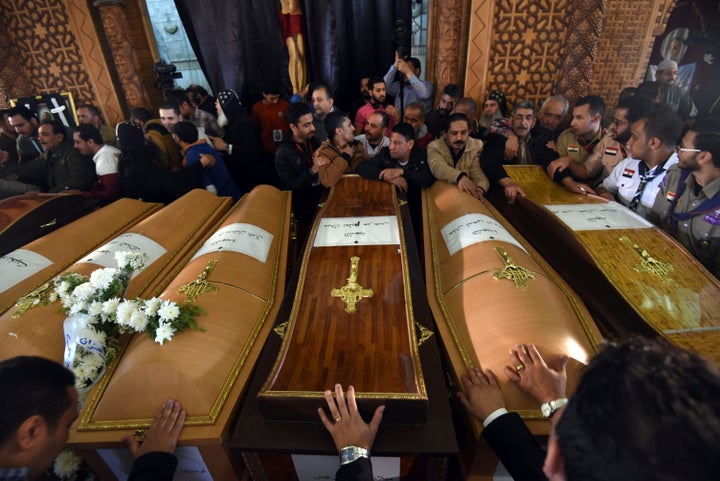 Mourners pray next to coffins of the victims of the blast at the Coptic Christian Saint Mark's church in Alexandria the previous day during a funeral procession at the Monastery of Marmina in the city of Borg El-Arab, east of Alexandria on April 10, 2017.