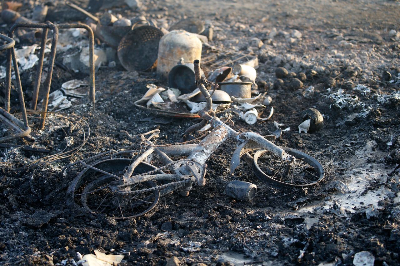 A child's bicycle is seen among the debris