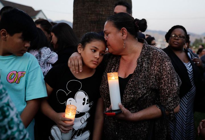 Betty Rodriguez, right, comforts her granddaughter during a vigil to honor the shooting victims at North Park Elementary School, Monday, April 10, 2017, in San Bernardino, Calif. 