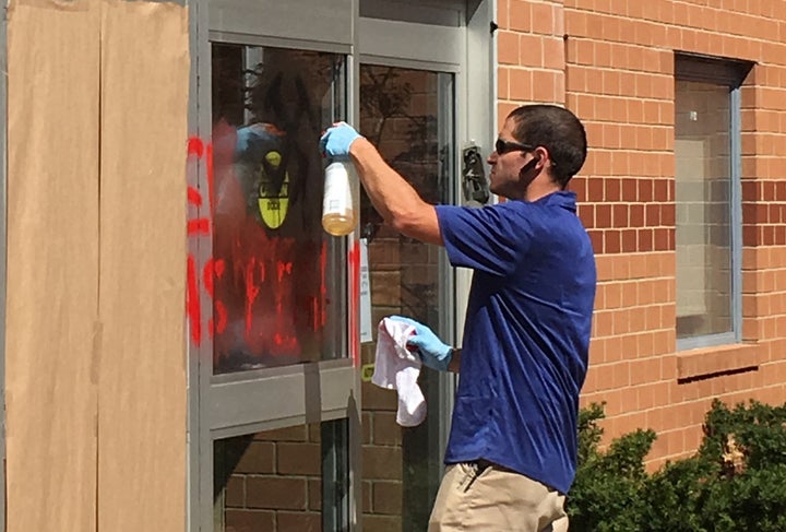 A man scrubs anti-Semitic graffiti from the Jewish Community Center of Northern Virginia in Fairfax, Virginia, on April 11, 2017.