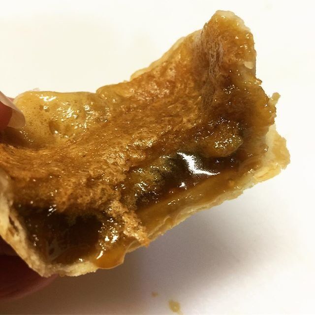 A close up of a butter tart and its glorious gooey filling.