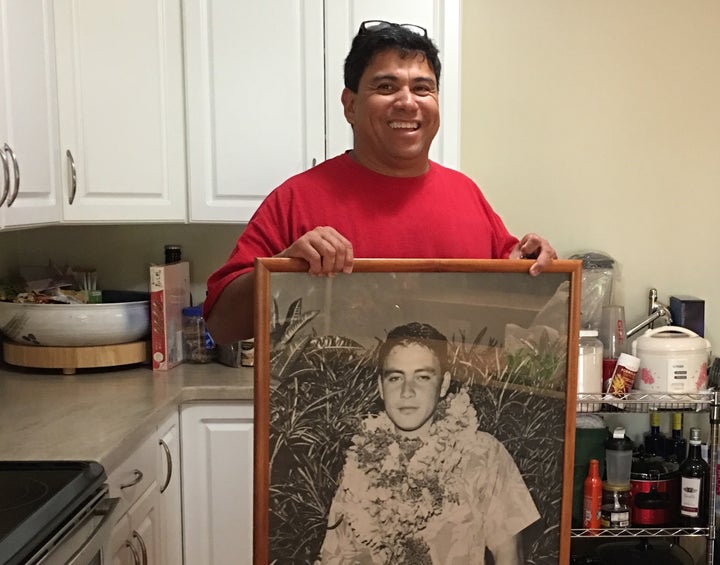<em>Standing in the middle of his spotless kitchen, Freitas holds up a large photo of his father from his youth. </em>
