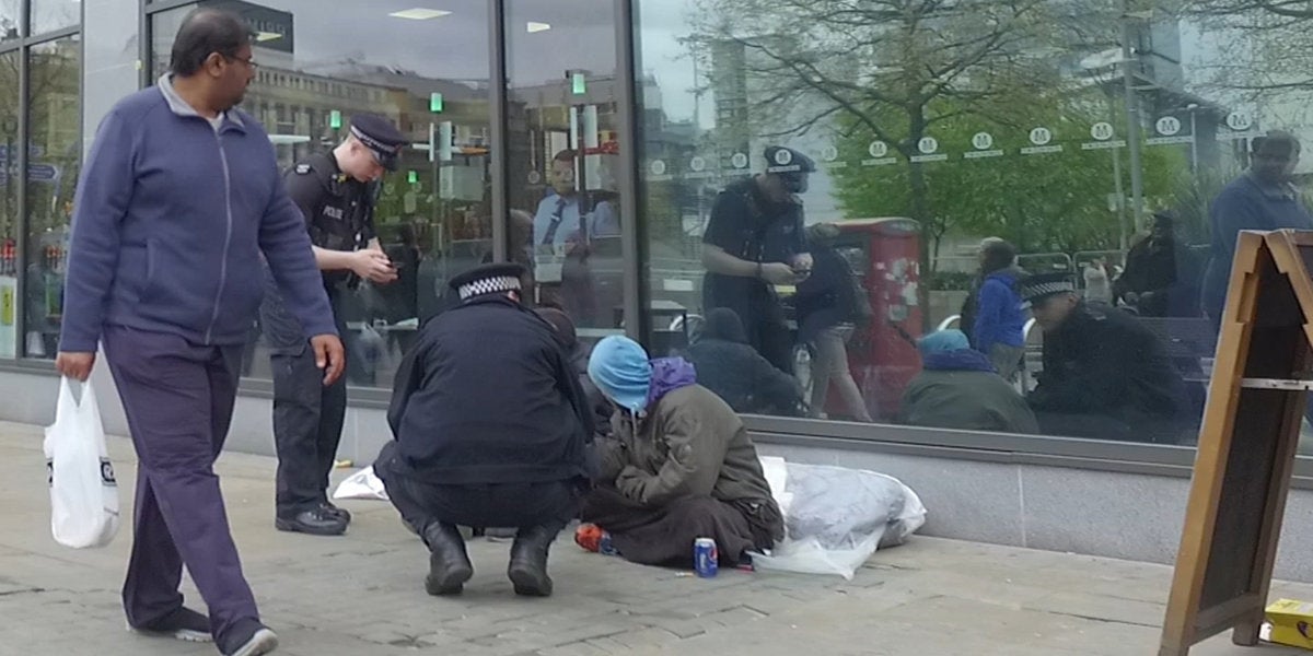 Two police officers check the wellbeing of a homeless man near Piccadilly Gardens in Manchester this week