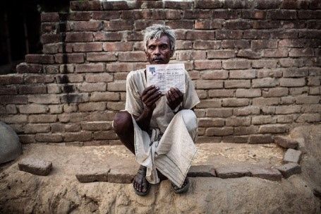 52-year-old Ram Kishen with his government provided ration card in Satnapur Village, Uttar Pradesh, India