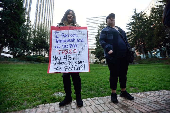 A woman holds up a sign made of tax returns in Portland, Oregon, on Feb. 28, 2017.
