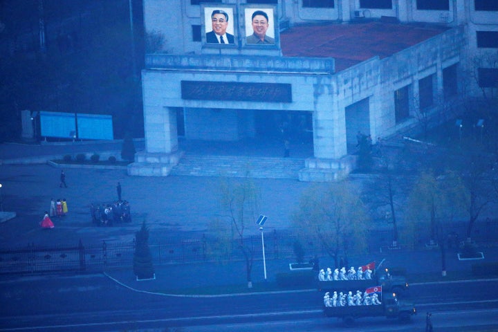 Military trucks carry soldiers through central Pyongyang before sunset as the capital preparers for a parade marking today's