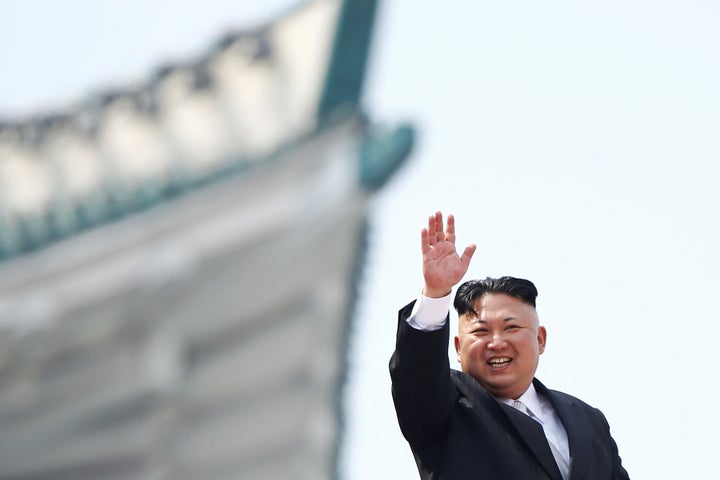 North Korean leader Kim Jong Un waves to people attending a military parade marking the 105th birth anniversary of country's