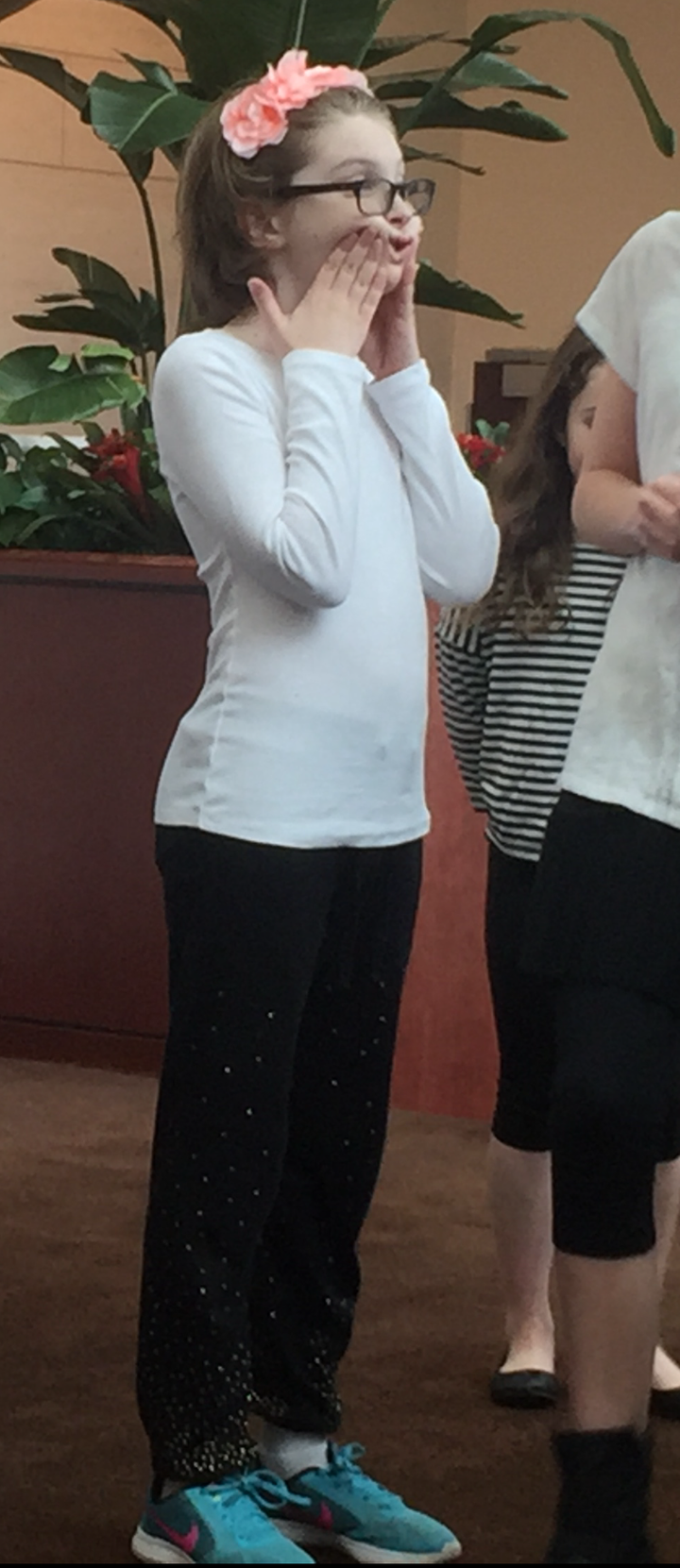 <p><em>Charlie, warming up their cheeks for a choral concert, wearing their pink signature floral headband.</em></p>