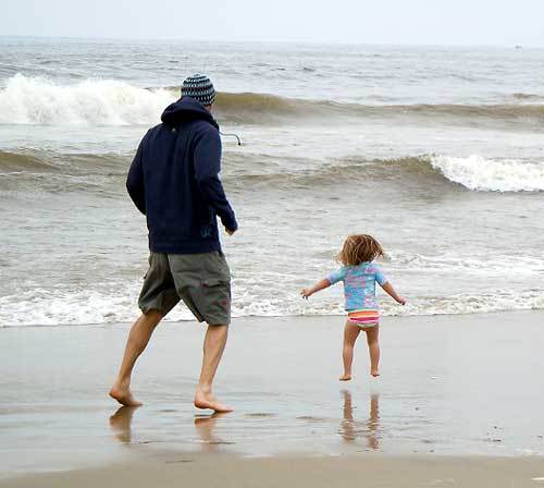 Chris Williams and his daughter play together down by the edge of the Pacific Ocean