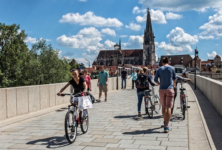 <p>he stone bridge over the Danube, built in 1146, connects Regensburg’s “new town” with the historic “old” town on the far side. At rear, the Strudel Tower, so-named for “the whirlpool eddies, or strudels, in the river below,” said City guide Ulrike Unger. The oldest of Regensburg’s 20 towers, they count less than half of the 50 towers that once graced this medieval town. Regensburg, Germany</p>