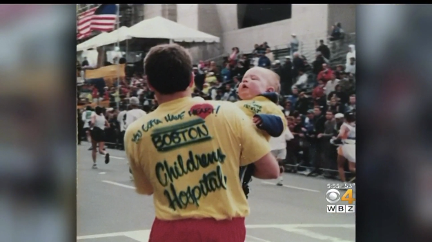 Dave Prario (left) carries his son Austin across the Boston Marathon finish line in 1998.