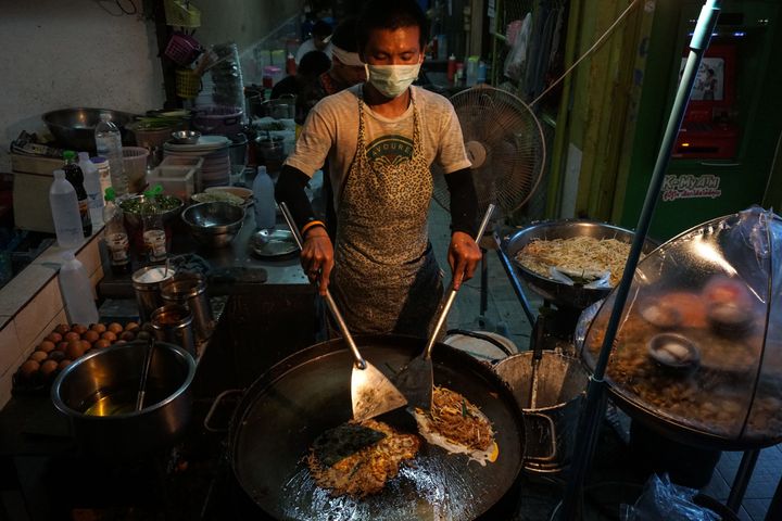 A man making food at a street stall in the Phrakanong district of Bangkok.