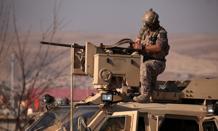 An American soldier sits in a military vehicle in the town of Bashiqa, east of Mosul, during an operation to attack Islamic S