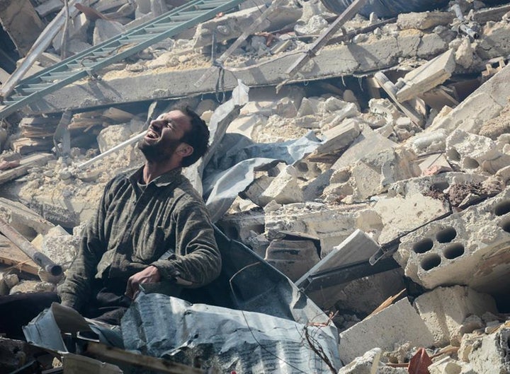 <p>A Douma man waits for news of his wife and child buried beneath the ruins of their house. His wife survived while his child did not </p>