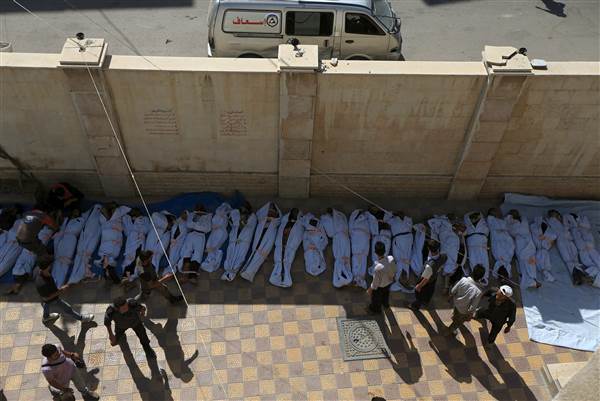 <p>People attempt to identify bodies after airstrikes in Douma, Syria </p>