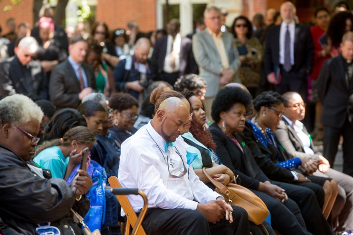 An audience participates in a moment of silence in front of Isaac Hawkins hall during a dedication of it and neighboring Anne Marie Becraft hall at the university after a Liturgy of Remembrance, Contrition and Hope on the campus, in Washington D.C., Tuesday, April 18, 2017.