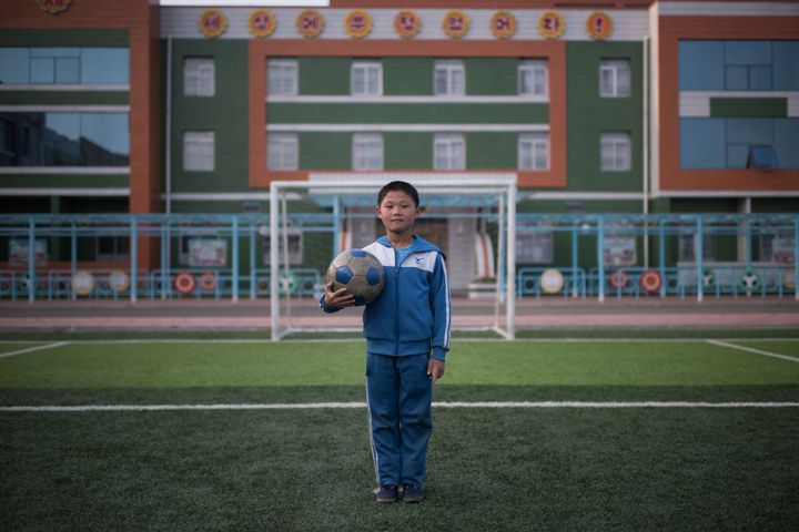 In a photo taken on April 13, 2017 Jong Kwang-Hyok (10) poses for a portrait on a football field at a school for orphans on the outskirts of Pyongyang.