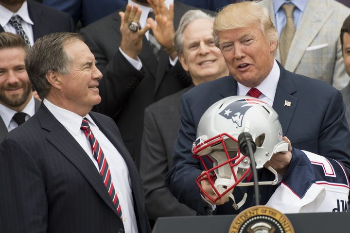 Donald Trump holds a football helmet given to him by New England Patriots head coach Bill Belichick.