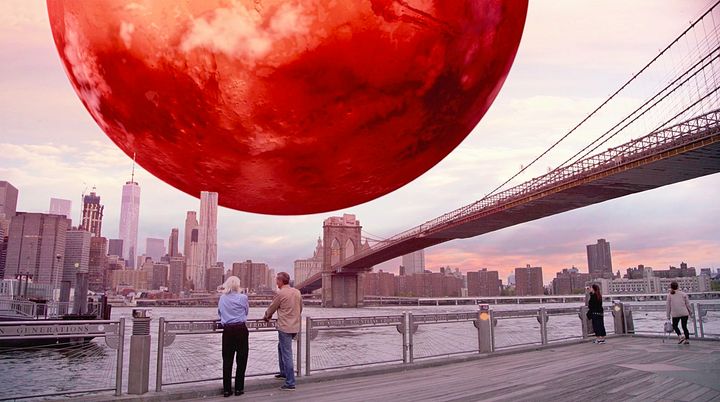 In “Miniverse,” we see Col. Chris Hadfield and theoretical physicist Michio Kaku appearing to look out over New York’s East River to view the planet Mars, hovering above Manhattan.