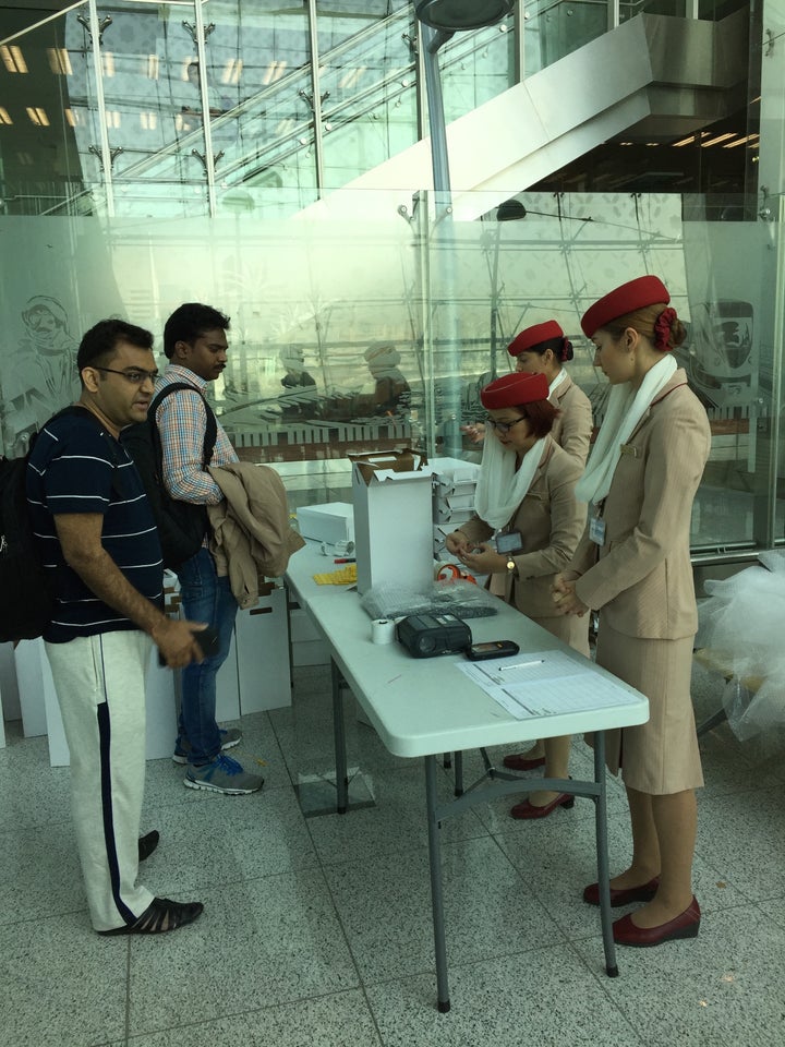 <p>Emirates staff allowing travelers to check-in their laptops</p>